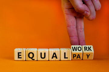 Equal pay and work symbol. Businessman turns wooden cubes and changes words equal pay to equal work. Beautiful orange background. Copy space. Business and equal pay and work concept.