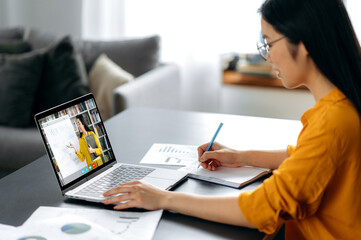 Asian female student watching lesson online and studying from home. Japanese or chinese girl taking...
