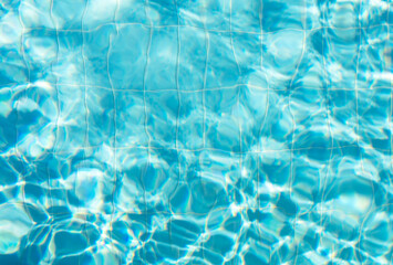 Blue ripped water with waves and rays in the swimming pool Summer vacation Background. Top view...