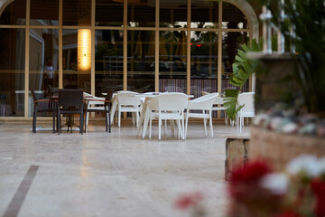 Fototapeta na wymiar Beach bar, tables and chairs in bright sunny weather. Summer and vacation concept