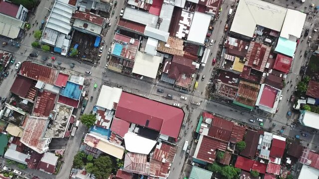 The drone shows the irregular architecture of a small Asian city.