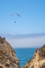 Paraglider by ocean cliffs