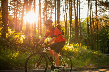 Male bicyclist on tour with his dog in forest