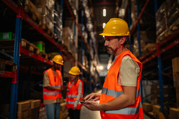 Handsome man warehouse worker with a tablet.