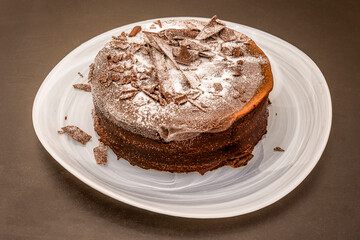 wonderful cake with three chocolates in different textures sprinkled with icing sugar