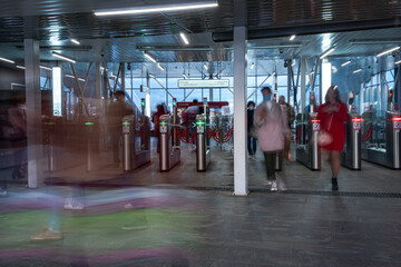 passengers passing through the turnstiles of the subway,