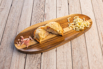 Argentine ham and cheese empanada on wooden board