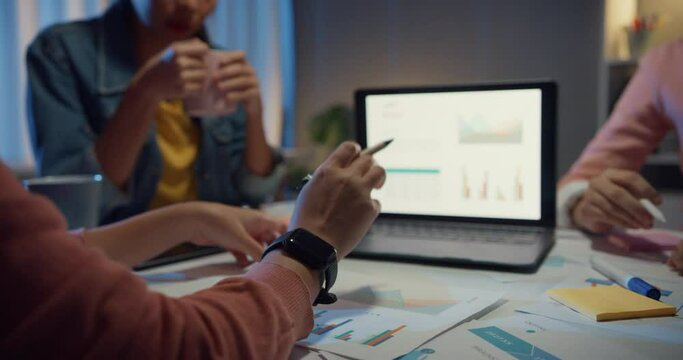 Millennial Asia people strategic meeting presentation brainstorming ideas about new paperwork project colleagues working together plan success strategy enjoy teamwork in small modern night office.