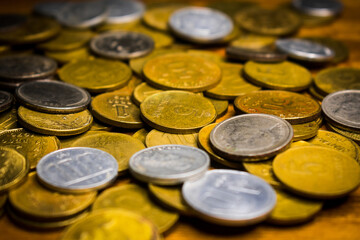 Many old coins of silver and gold color on a table. Close-up.