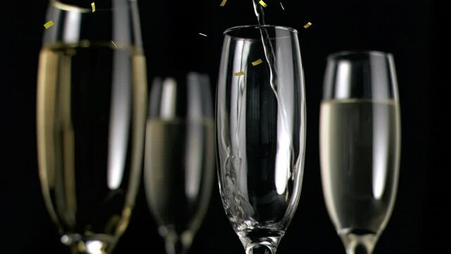 Animation of champagne glasses and champagne pouring, with gold confetti falling on black background