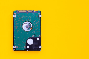 Hard disk drive of computer on yellow background.