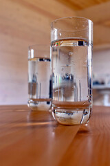 Two glasses of water close-up on a wooden table