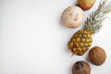 Exotic fruits, pineapple and Coconut, on white stone table background, top view flat lay, with copy space for text