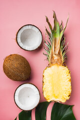 Exotic fresh fruits, pineapple and Coconut, on pink textured summer background, top view flat lay