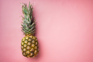 Pineapple whole, on pink textured summer background, top view flat lay, with copy space for text