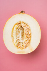 Melon cut, on pink textured summer background, top view flat lay