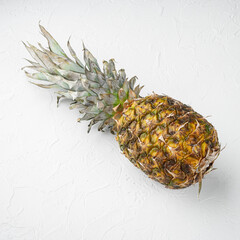 Pineapple whole, on white stone table background, top view flat lay, square format