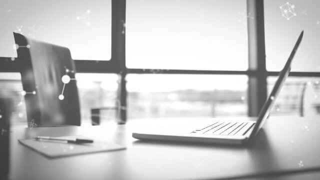 Animation of molecules moving over laptop on desk