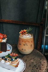 Iced caramel latte coffee with syrup and whipped cream decorate with flower. Coffee break at retro style coffee shop