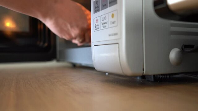 Point of view shot of a man using a microwave oven in a kitchen. 4k stock footage.