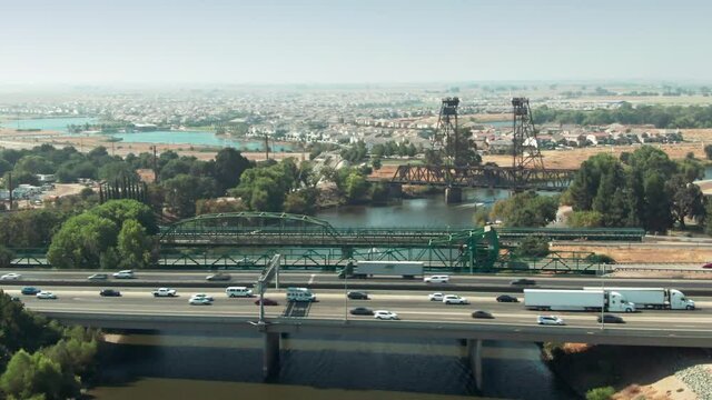 Aerial: Interstate 5 freeway traffic crossing the San Joaquin River. Stockton, California, USA