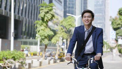 young asian business man commuting by bike in downtown of modern city