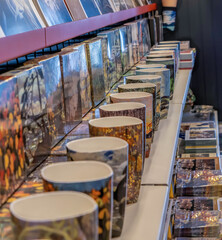 Colourful ceramic mugs and boxes of cards on a store display, nobody