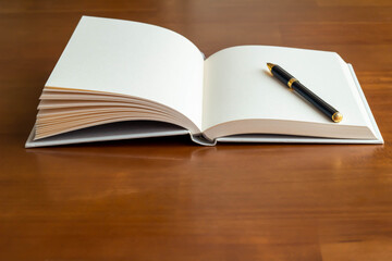 テーブルに置かれたまっさらな本とボールペンのクローズアップ