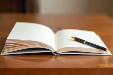 テーブルに置かれたまっさらな本とボールペンのクローズアップ