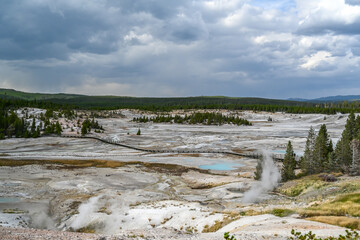 A geyser, steam and water boils from the ground in the well known preserve park