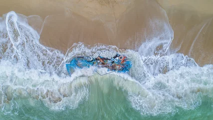 Foto auf Acrylglas Broken boat and fishing nets washed up on a beach fish shape water sand debris waste plastic wood environmental global warming concept © Huw Penson