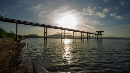 Obraz premium Panoramic natural background of green meadows along the reservoir, surrounding roads and winds and beautiful morning sunlight.