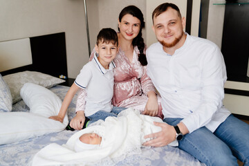 the first day of the newborn at home. Happy family with a toddler in the bedroom