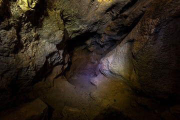 Chandolaz ridge cave in the Primorsky region. A deep cave illuminated by a flashlight.