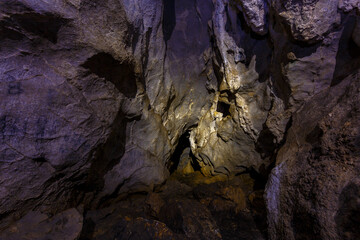Chandolaz ridge cave in the Primorsky region. A deep cave illuminated by a flashlight.