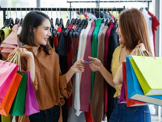 Cheerful female Asian shoppers showing credit card