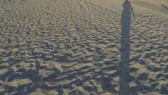 Legs shiloutte on a sand beach. Slow motion.