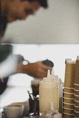 Unrecognizable  barista man smiles and happy as enjoy decorating creamy foam of cold drinks in...
