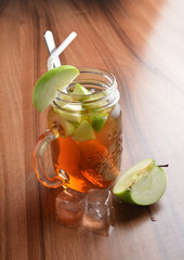 cold green apple fruit ice tea with white straw on wood table cocktail chilled beverage menu