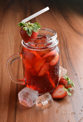 cold fresh strawberry fruit ice tea kombucha with white straw on wood table cocktail chilled beverage menu