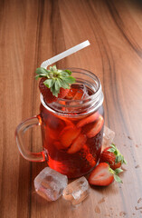 cold fresh strawberry fruit ice tea kombucha with white straw on wood table cocktail chilled beverage menu