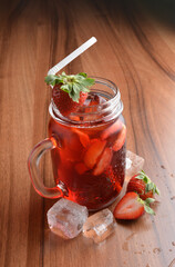 cold fresh strawberry fruit ice tea kombucha with white straw on wood table cocktail chilled beverage menu