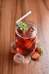 cold fresh strawberry fruit ice tea kombucha with white straw on wood table cocktail chilled beverage menu