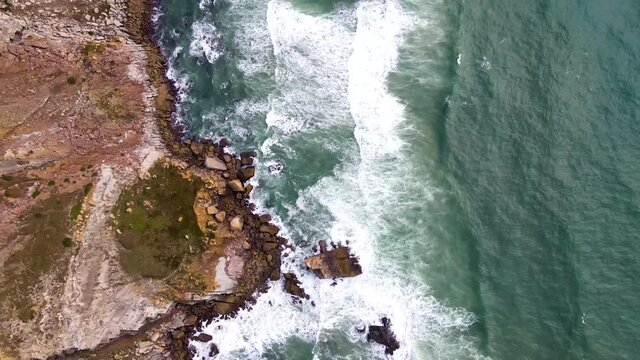 Top View Of Ocean Waves Crashing At The Rocky Coastline In Silver Coast, Portugal. aerial