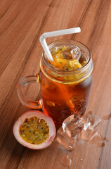 cold passion fruit ice tea kombucha with white straw on wood table cocktail chilled beverage menu