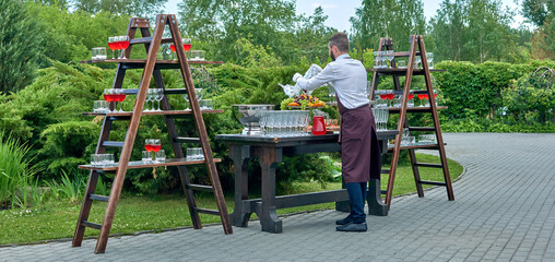 Summer banquet on the street. Event. Wedding. Event. Waiter. Catering. A party. Glasses of wine. Champagne.