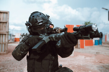 soldier holding rifle at the battlefield area ready fight. Concept of BB gun combat warrior style.