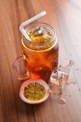 cold passion fruit ice tea kombucha with white straw on wood table cocktail chilled beverage menu