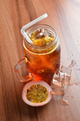 cold passion fruit ice tea kombucha with white straw on wood table cocktail chilled beverage menu