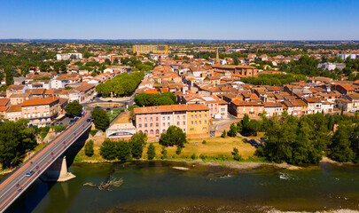Fototapeta na wymiar Flight over the city Muret and Garonne river on summer day. France
